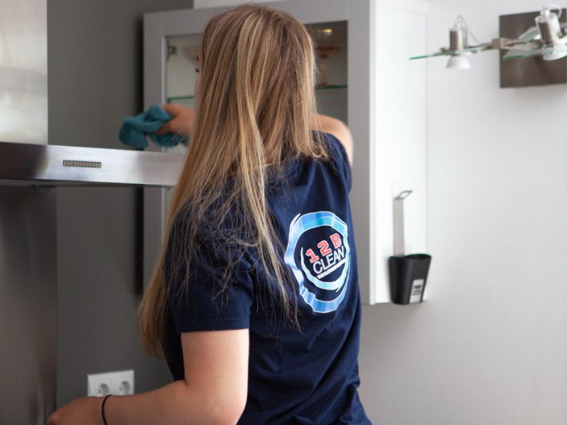 Schoonmaakster bezig met reguliere schoonmaak in keuken