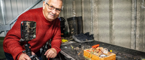 Rodney Holbrook bij zijn werkbank met zijn camera.